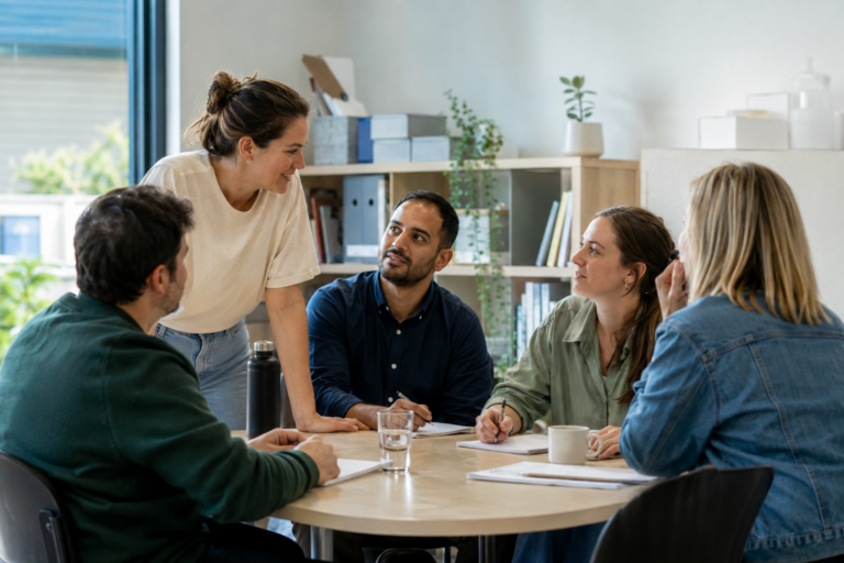 Small not-for-profit team discussing workplace wellbeing in a bright community office